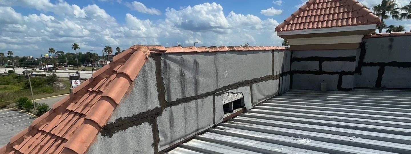 Before: aging low-slope metal roof and worn parapet at the Quality Inn